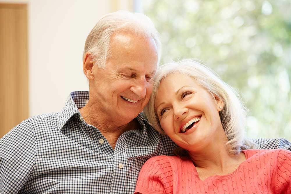 Older couple smiling together after a root canal